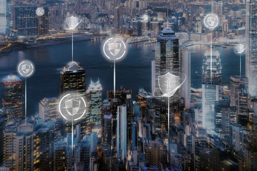 Skyline bei Dämmerung mit beleuchteten Fenstern und Symbolen für digitale Sicherheit